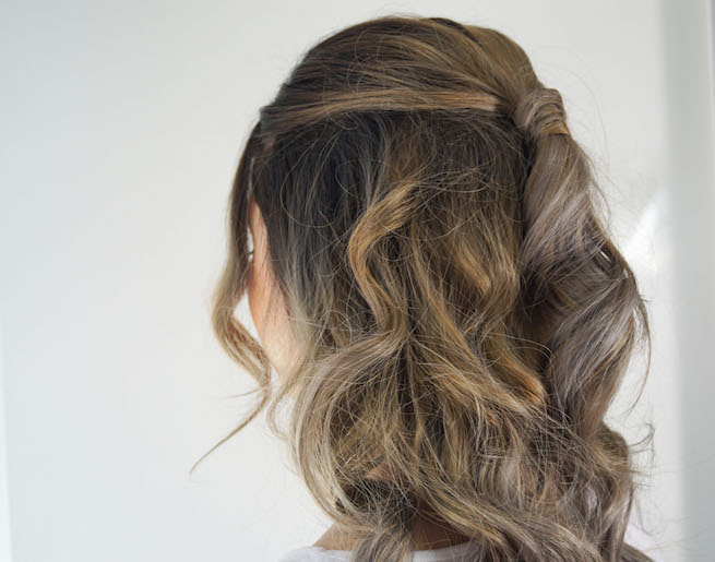 Back of head photo of woman with half up half down curled hairstyle