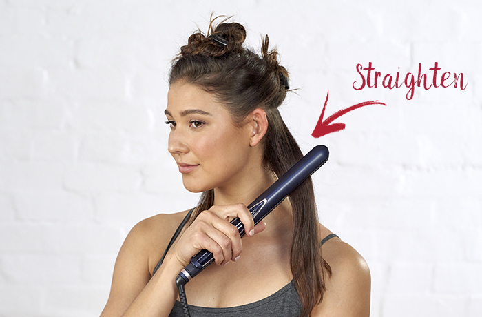 Woman straightening hair